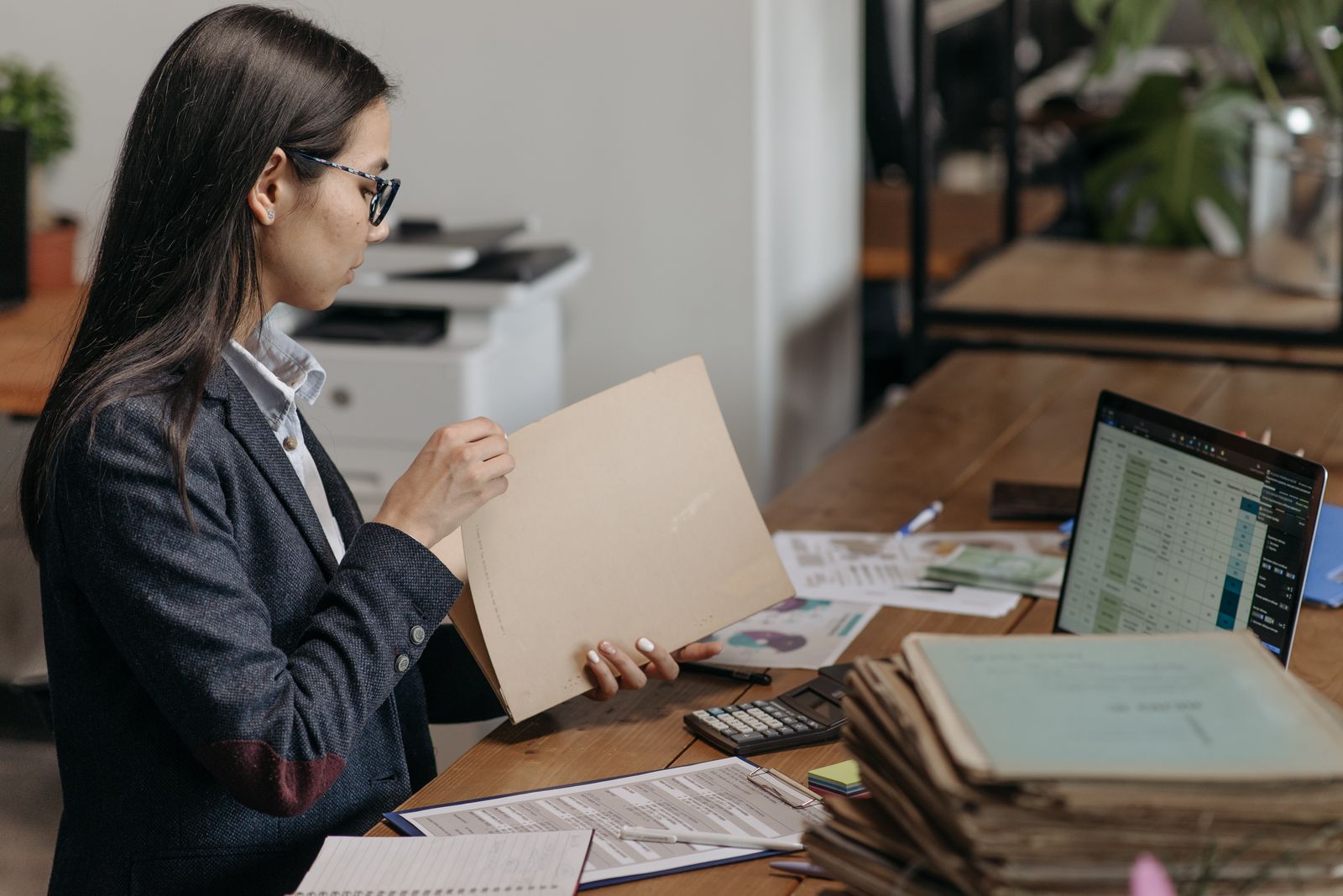 Professional reviewing a file at an office desk